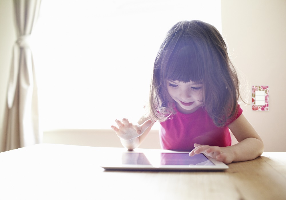 4 year old girl using digital tablet on table